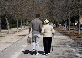 Un hombre de mediana edad pasea junto a una anciana.