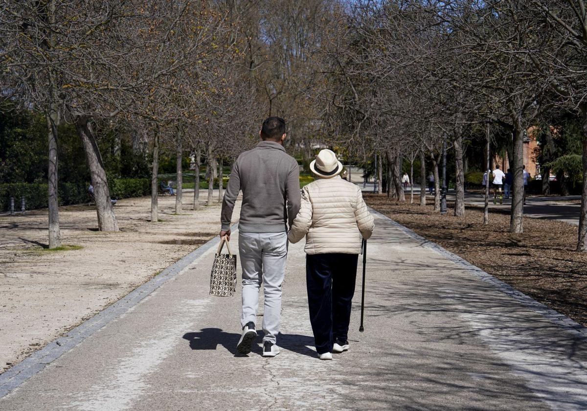 Un hombre de mediana edad pasea junto a una anciana.
