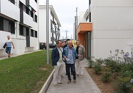 El portavoz de la comisión de propietarios, Juan José Jiménez, conversa con Zapico frente a uno de los bloques, junto al edil Gilberto Villoria.