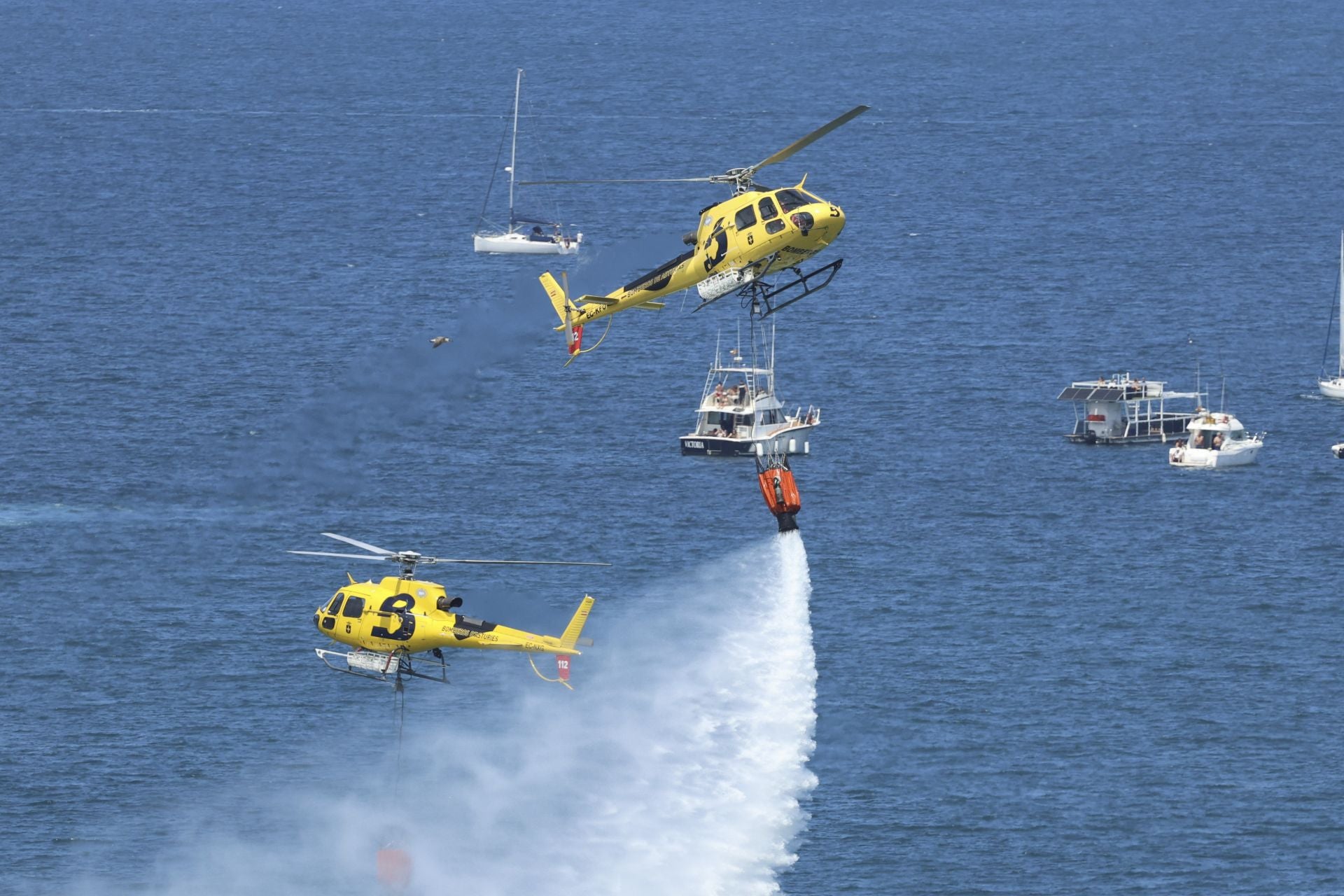Dos de los tres helicópteros de Bomberos de Asturias que participaron en el certamen, durante la exhibición.