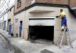 Operarios de limpieza, en el bajo de la calle San Matías, en Gijón.