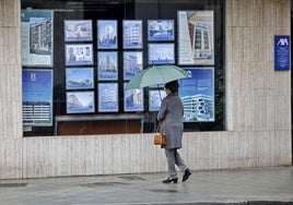 Una mujer frente a una inmobiliaria.