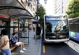 Varias personas esperan el autobús en Oviedo.