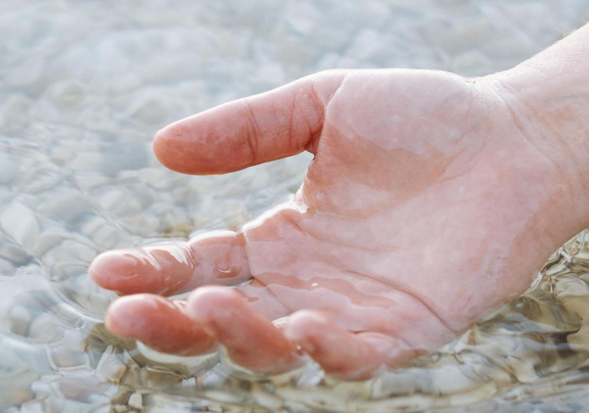 Una mano dentro del agua.