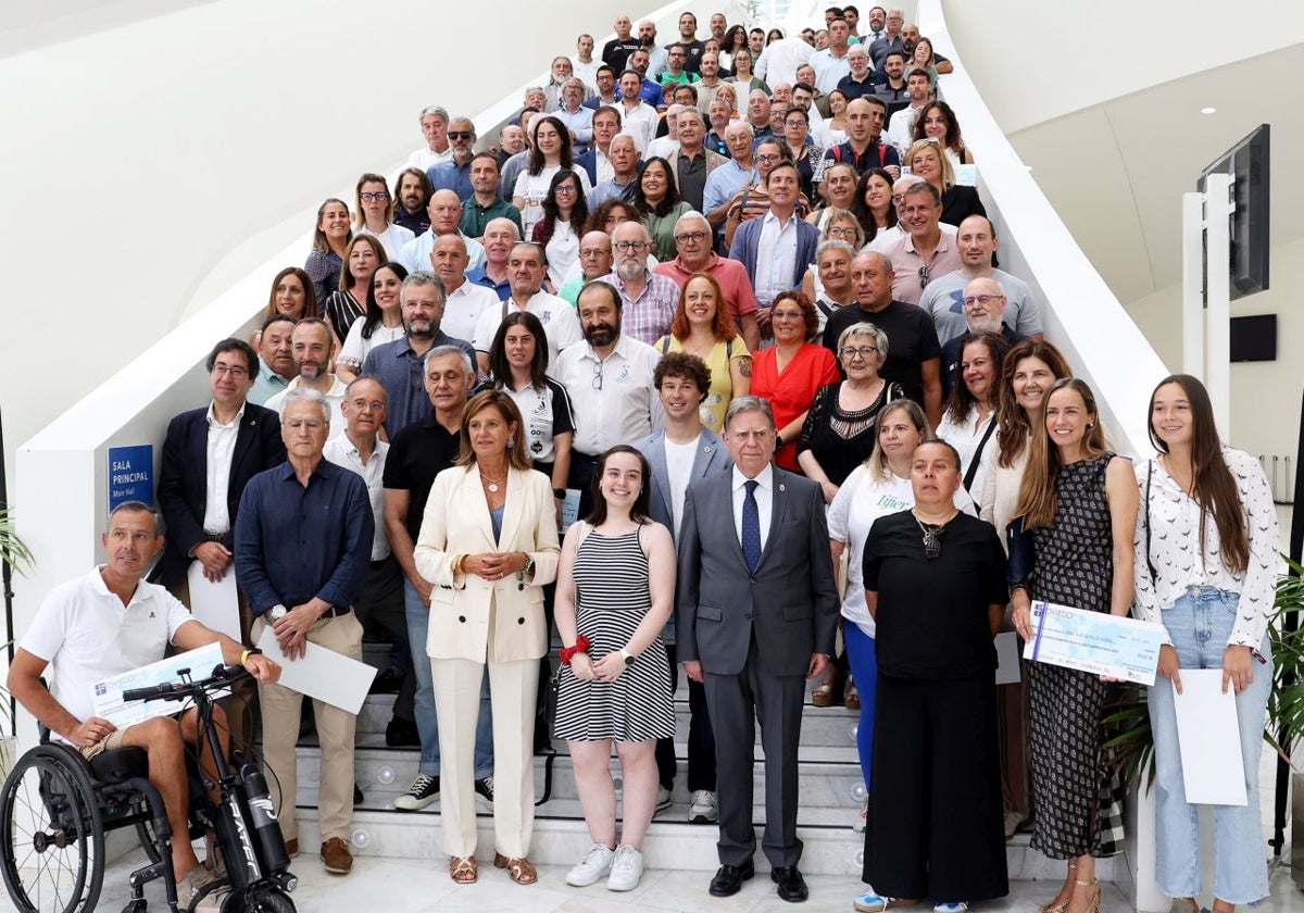 Foto de familia de los deportistas y directivos con el alcalde, en la escalera interior del Calatrava.