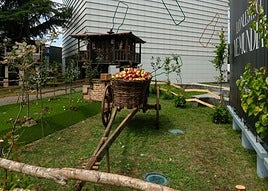 Tradición.Un carro con manzanasy un hórreo, en la caseríareproducida en el exterior.