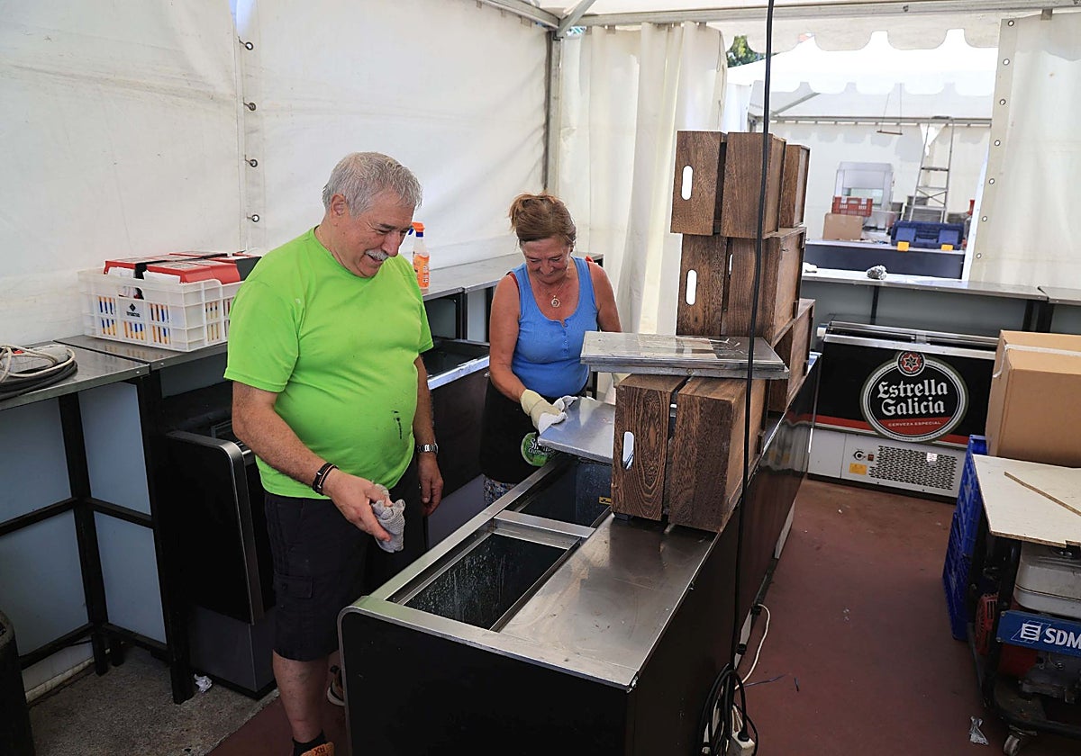Dos hosteleros preparan la barra de uno de los bares que participan en el Festival de la Cerveza.