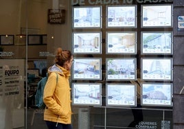 Una mujer observa las ofertas de una inmobiliaria.