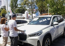 Dos personas ante un coche kilómetro cero en la Feria.