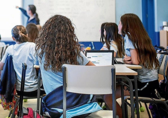 Unas alumnas siguen la clase con sus dispositivos digitales.
