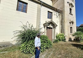 El párroco de la iglesia de Pola de Siero, Fermín Riaño, señala uno de los desperfectos de la fachada