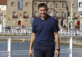 El técnico del Sporting pasea por la zona del Puerto Deportivo, con el Palacio de Revillagigedo de fondo.