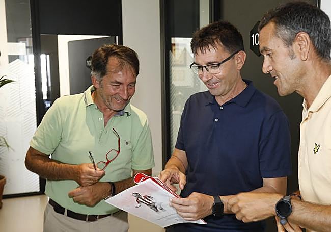 Garitano sujeta el especial por el 120 aniversario del Sporting del periódico EL COMERCIO en presencia de su director, Ángel González, y el jefe de Deportes, José Ángel García.