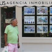 Un hombre pasa por delante del escaparate de anuncios de una agencia inmobiliaria.