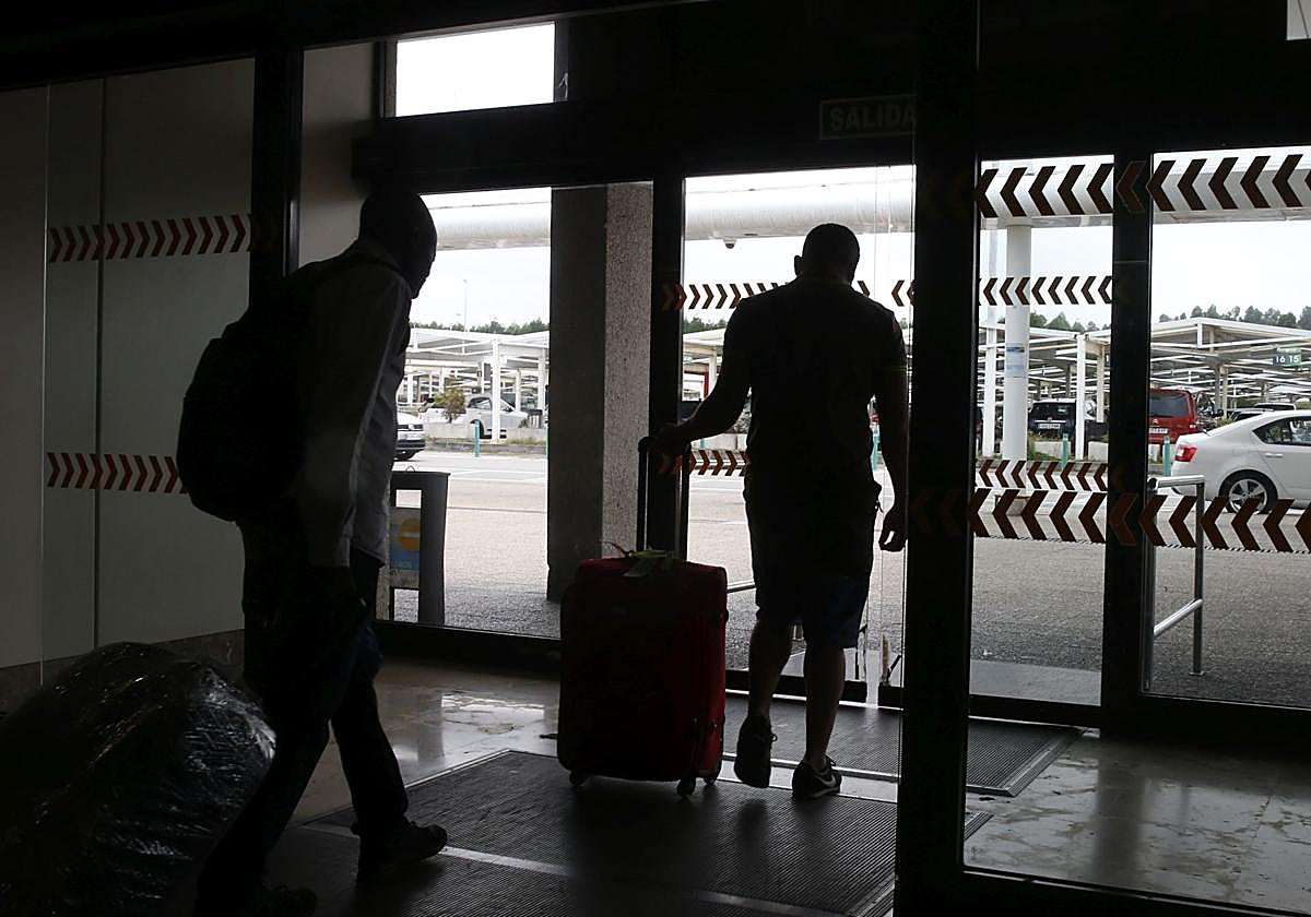 Unos turistas abandonan la terminal de Santiago del Monte.