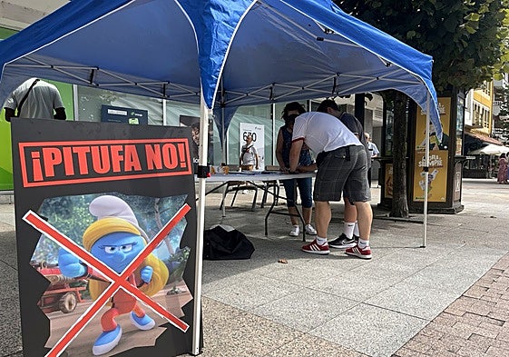 Cartel de rechazo de la Pitufa Karateca, junto a la mesa de recogida de firmas de La Pola.