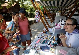 Una clienta le pregunta por un diseño de ropa a Aida Díaz.