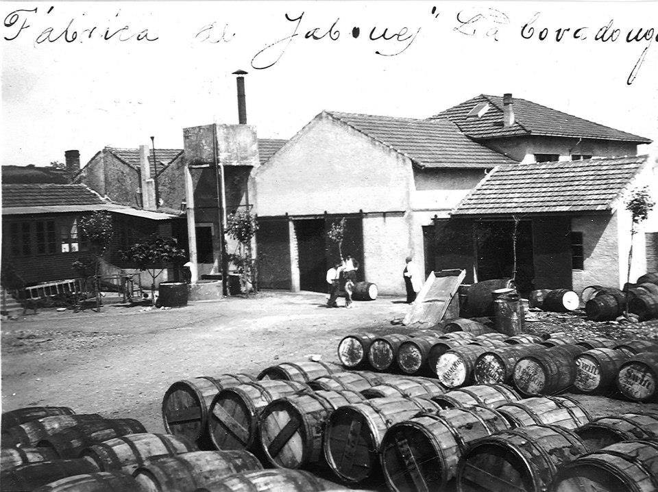 Fábrica jabonera La Covadonga rodeada de barriles de sosa para hacer el jabón. El hombre da bata es RamónMenéndez Medina, el dueño. Fecha: ca. 1935. Foto: cortesía de Avelino Rodríguez.