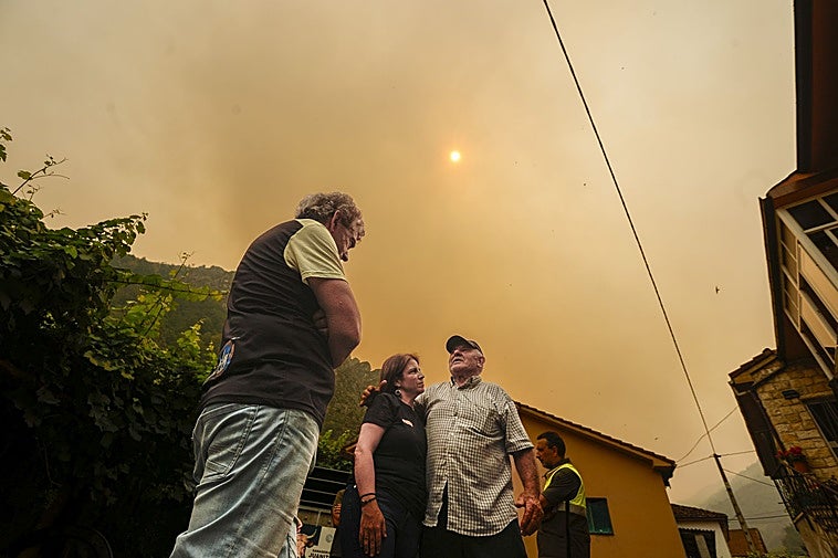 La delegada del Gobierno, Adriana Lastra, habla con Manuel González, quien fuera alcalde de Somiedo, y con el actual regidor, Belarmino Fernández, sobre la situación de los incendios forestales en Asturias.