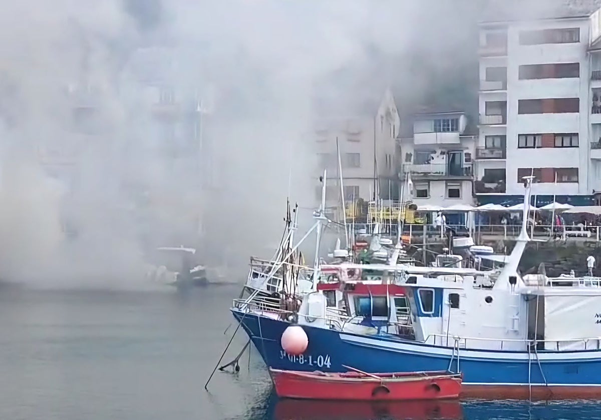 Una embarcación quemándose en el puerto de Luarca.
