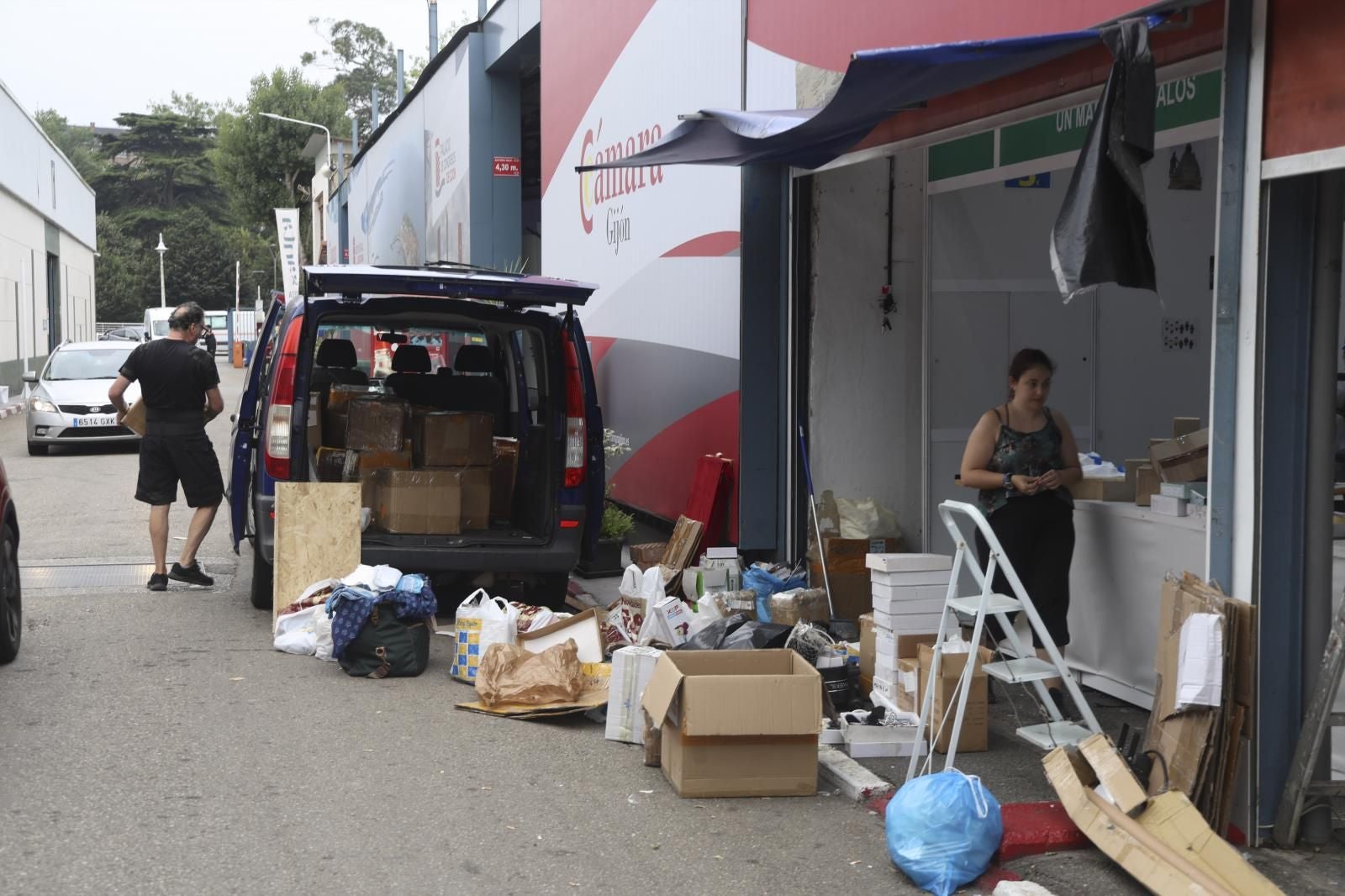 Uno de los expositores recoge su mercancía en cajas de cartón y bolsas.
