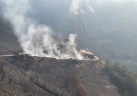 Una nave ganadera de Cangas del Narcea, con sus balas de paja calcinadas, en medio de un paisaje arrasado por las llamas.