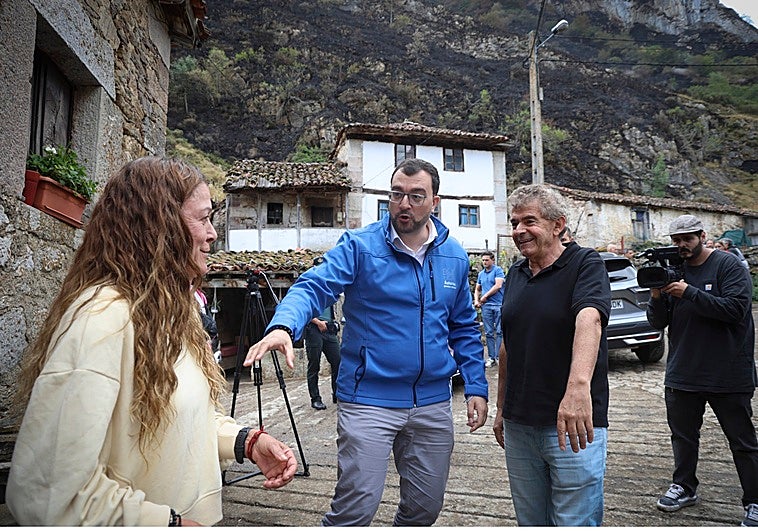 Adrián Barbón saluda a la alcaldesa pedánea de Perlunes, Dolores Fernández, y al alcalde de Somiedo, Belarmino Fernández. En el vídeo: Un helicóptero suelta una descarga de agua en la zona de Somiedo