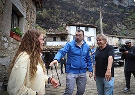 Adrián Barbón saluda a la alcaldesa pedánea de Perlunes, Dolores Fernández, y al alcalde de Somiedo, Belarmino Fernández. En el vídeo: Un helicóptero suelta una descarga de agua en la zona de Somiedo