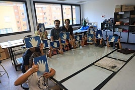 Los niños del taller de cianotipia muestran uno de los primeros trabajos realizados con Nicolás y Cristina.