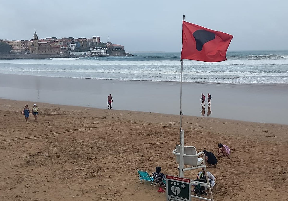 Bandera roja en San Lorenzo, en Gijón, esta tarde.