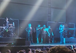 Miembros de la orquesta Tekila, en el escenario, tras detener su actuación en las fiestas de Contrueces de Gijón por un botellazo que golpeó a uno de los cantantes.