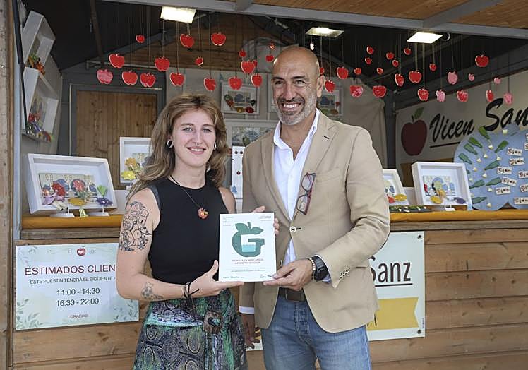 Alba Alonso, ayudante de Vicen Sanz, recibe el diploma de manos de Óliver Suárez (Divertia) en la caseta de la ceramista.