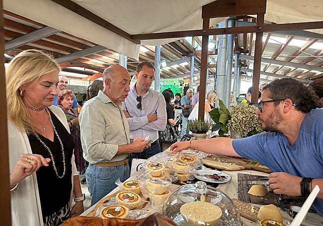 Adrián Pumares, el primero por la izquierda, observa la venta de queso en Caso.