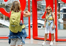 Una turista inmortaliza a su amiga ante las Letronas de Gijón.