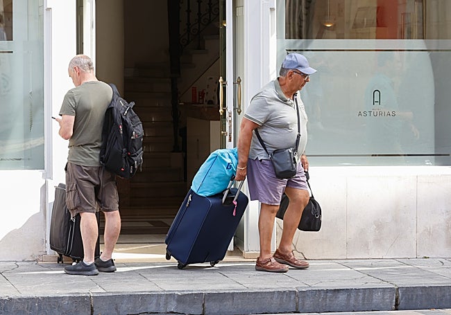 Dos turistas a las puertas de un hotel gijonés.