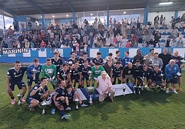 Los jugadores del Marino de Luanco celebran la Copa Federación sobre el césped, con sus aficionados de fondo.