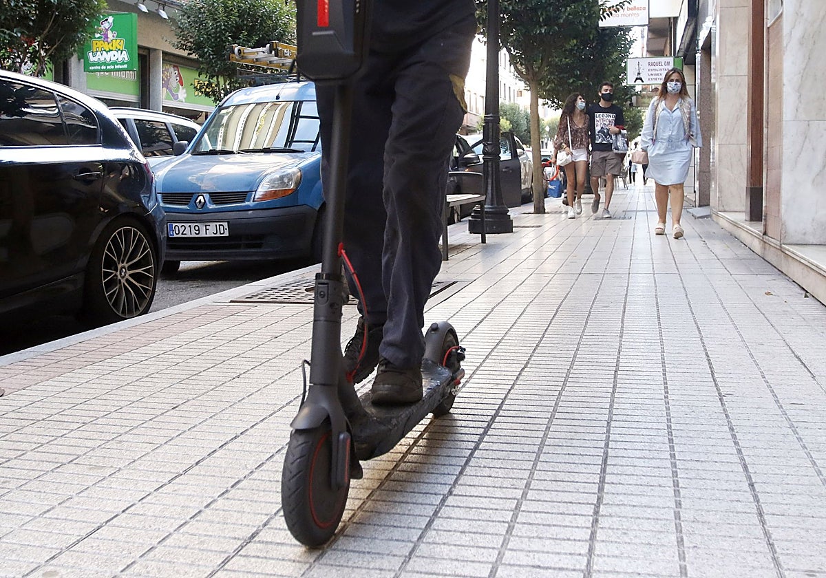 Un patinete eléctrico por las calles de GIjón.