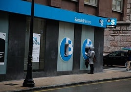 Una ciudadana opera en un cajero de Sabadell Herrero, la marca asturiana del banco catalán.