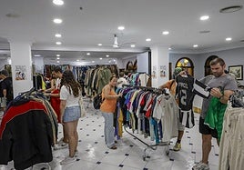 Algunos clientes eligen prendas en el mercado de ropa vintage de Jaleo Village, ubicado en el Hotel Alcomar.