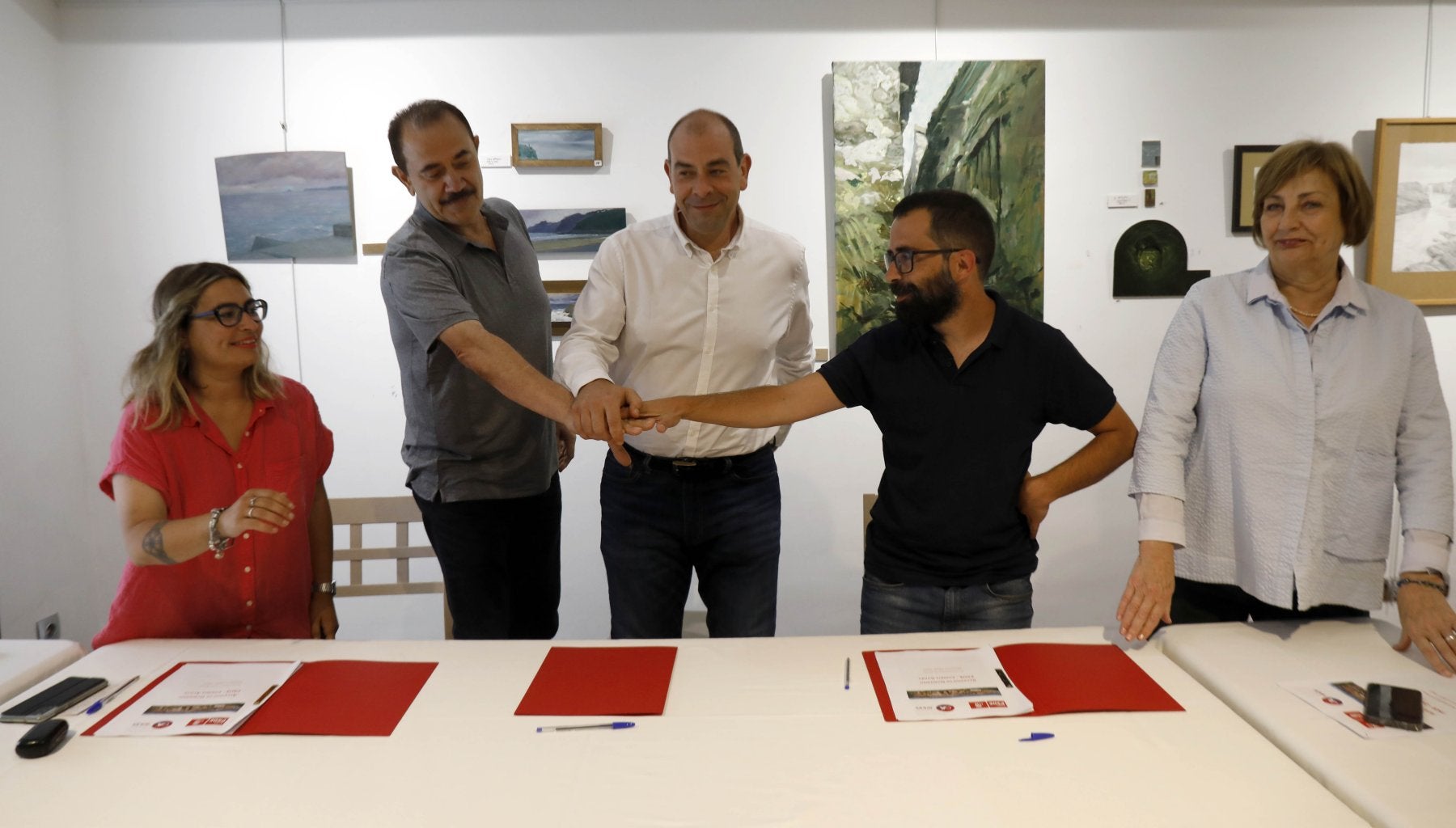 Juan José Fernández (IU) y David García (Podemos) unen su mano a Luis Huerga (PSOE), en el centro, en la firma del pacto de gobierno.