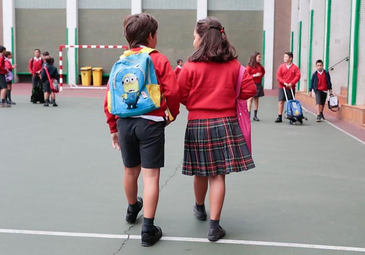 Dos niños caminan por el patio, en su primer día de actividad, en el Corazón de María (Codema) de Gijón, un centro concertado.
