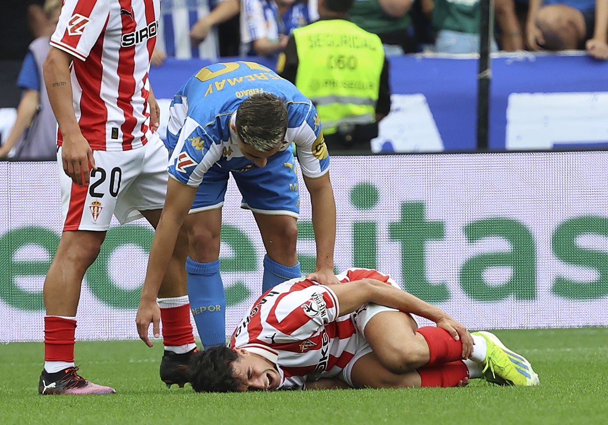 Nacho Martín, doliéndose sobre el césped de Riazor, con Yeremay de pie.