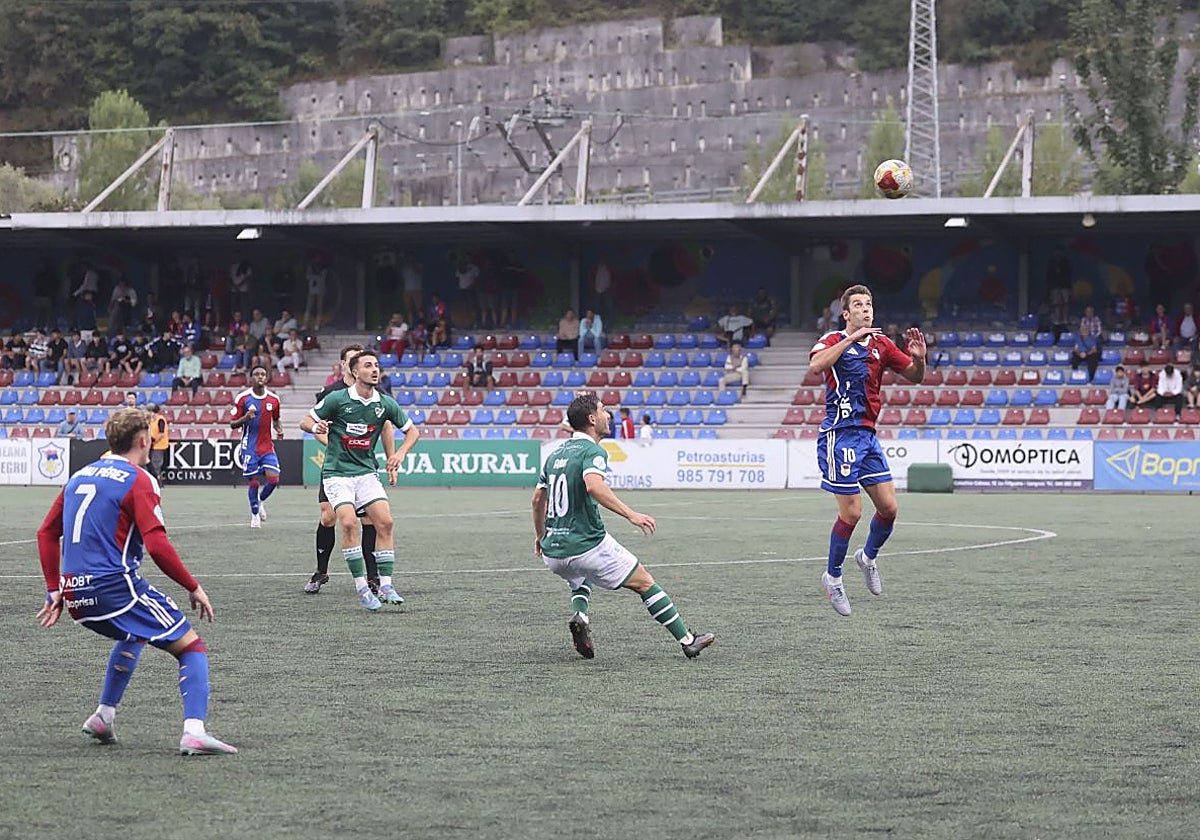 Juan López se dispone a hacer un pase de cabeza en el partido ante el Coruxo.
