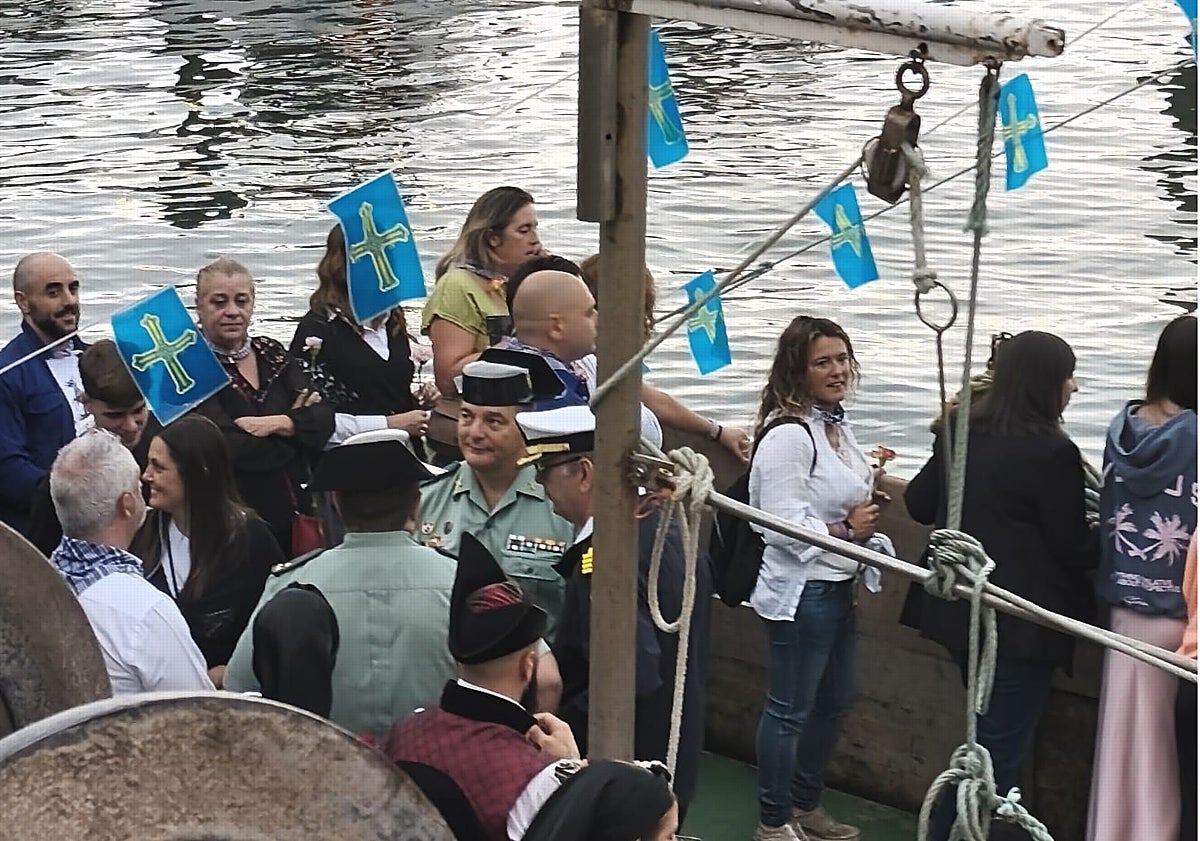 Imagen principal - La poeta del Alba en un barco, desde los que se arrojaron coronas a la mar. Y la procesión por las calles de Candás.