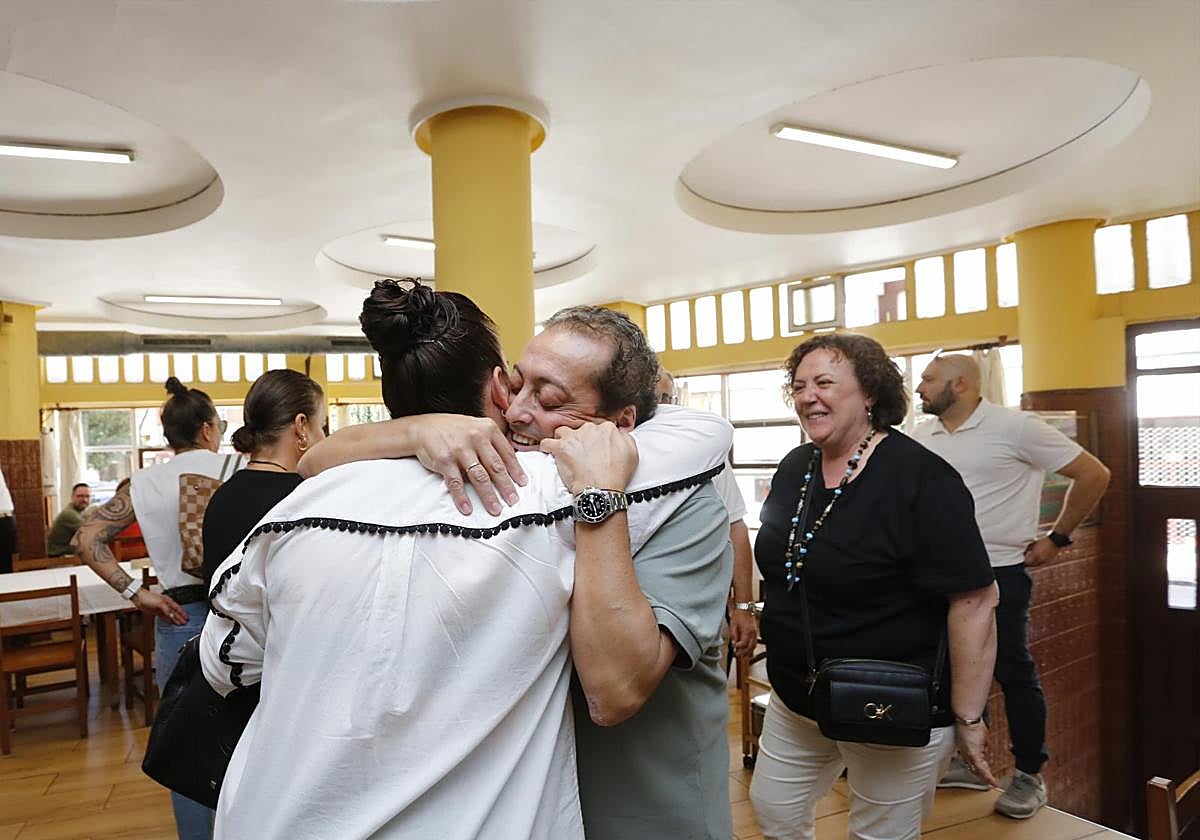 Víctor Fernández se abraza a una clienta en el último día de la sidrería El Chaflán.