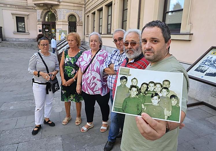 Marta María Guerra –sobrina de Avelino– con sus hijos Carmen, Margarita, Roberto y Juan Daniel, y su nieto Daniel, quien sujeta una foto de familia de Avelino con su mujer y sus ocho hijos.