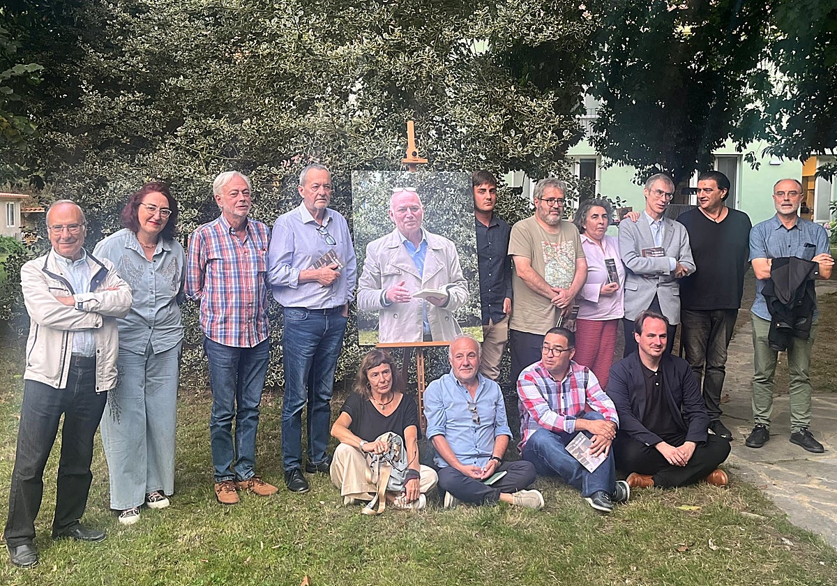 José Luis García Martín, Isabel Marina, Pedro Luis Menéndez, José Luis Argüelles, Juan Suárez, Ángel Alonso, Ángeles Carbajal, Javier Almuzara, Antonio Manilla y Francisco Alba. Sentados, Lourdes Álvarez, César Iglesias, Cristian David López y Carlos Iglesias. En el centro, una fotografía de Xuan Bello, en el mismo lugar, recitando poesía.