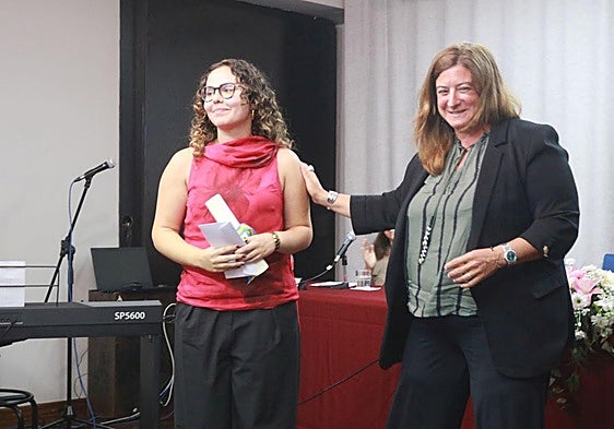 Irene García-Pumarino Arias recibe el diploma del premio Aurelio Menéndez-Mercedes García Quintana de manos de la directora del IES Jovellanos, Idoya Martínez, en el salón de actos del centro.