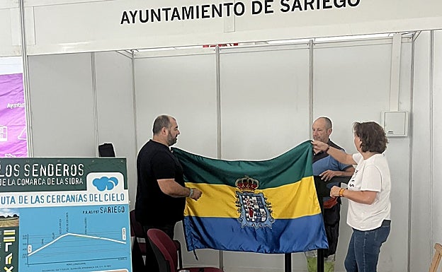 El alcalde de Sariego, Saúl Bastián (izquierda) , en el montaje del expositor en la plaza cubierta.