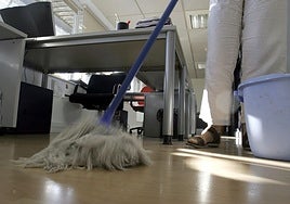 Una trabajadora limpia una oficina.